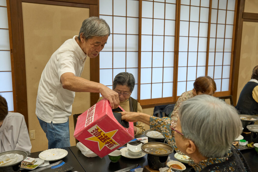 抽選箱から抽選券を取る会員さん