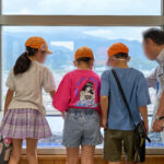 展望台から下の待ちを見る子どもたちとサポータ